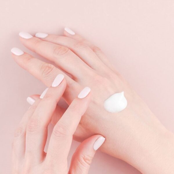 woman's hands applying small amount of personal care hand lotion