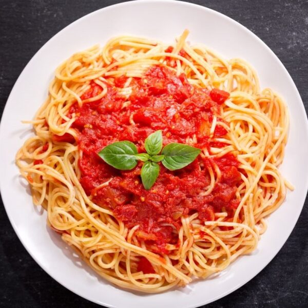 plate of spaghetti on black table
