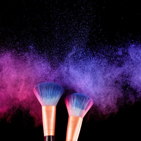 two cosmetic brushes with brightly colored cosmetic makeup