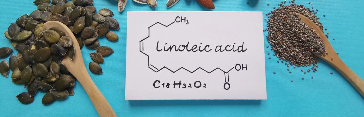 Linoleic acid chemical structure index card arranged on table with wooden spoons and seeds.