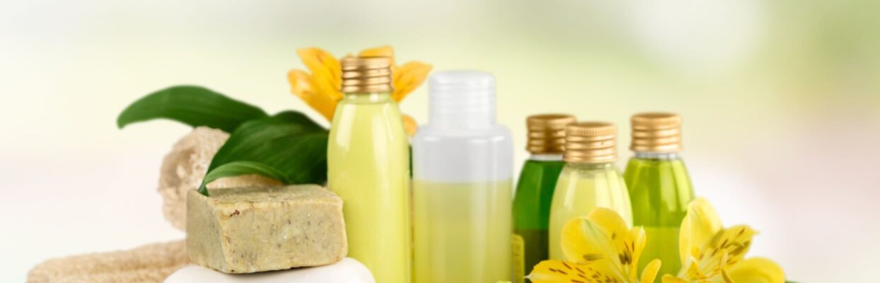liquid and bar soaps arranged with herbal flowers against a blurred background
