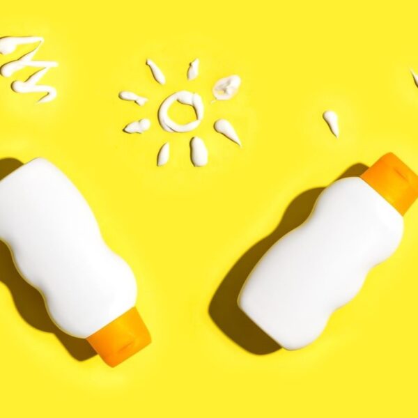 sunscreen bottles arranged on yellow background